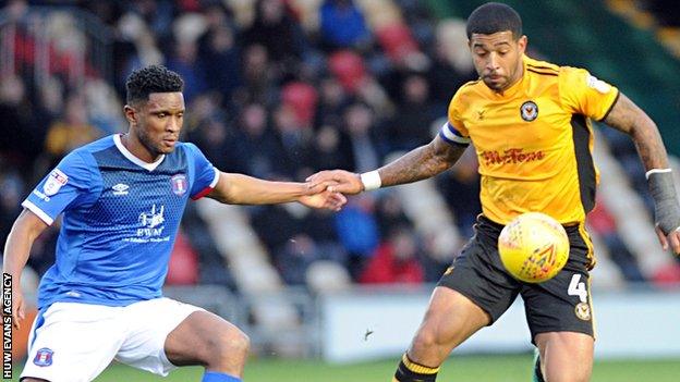 Joss Labadie attempts to control the bouncing ball for Newport as Carlisle's Kelvin Etuhu closes in