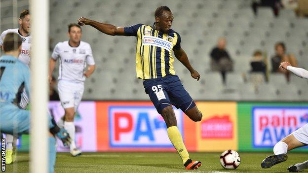 Olympic champion Usain Bolt takes a shot on goal while playing football for Central Coast Mariners