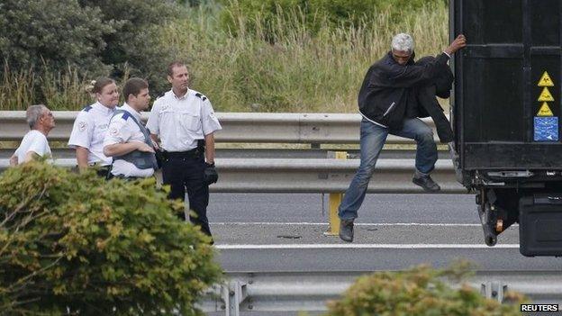 A migrant climbing down from a lorry in Calais