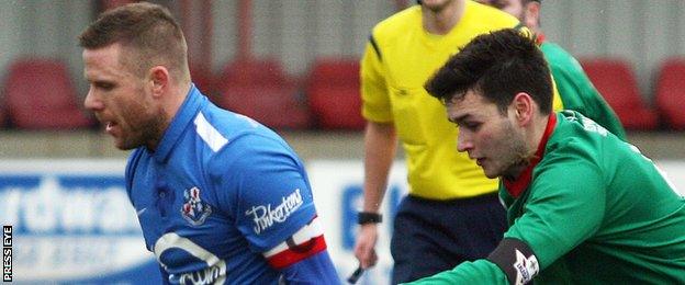 Loughgall's Steven Ferguson in action against Stuart Hutchinson of PSNI at Lakeview Park