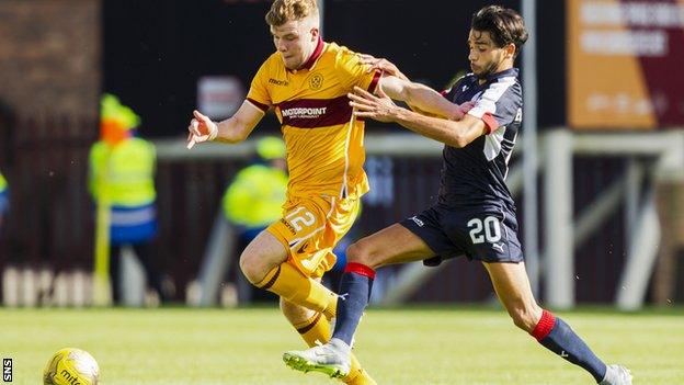 Motherwell's Chris Cadden is tackled by Dundee striker Faissal El Bakhtaoui