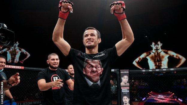 Usman Nurmagomedov celebrates with Khabib in the background