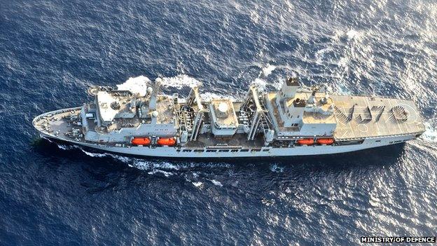 RFA and Royal Navy personnel spell out the message VJ70 on the deck of Royal Fleet Auxiliary ship Fort Victoria