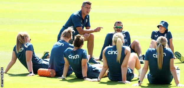 Jon Lewis speaks to England players during training