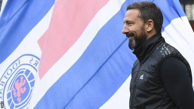 Aberdeen manager Derek McInnes in front of a Rangers fans' flag