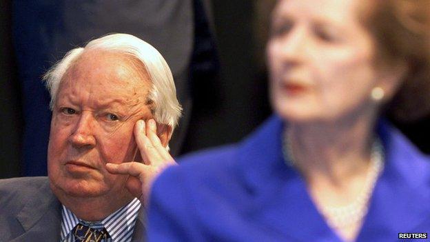 Edward Heath sitting behind Margaret Thatcher