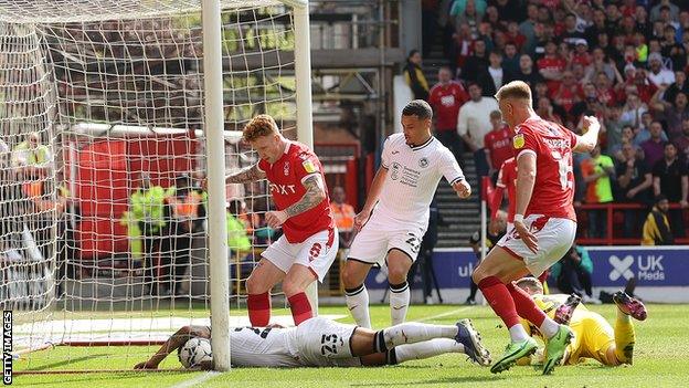 Cyrus Christie of Swansea City scores an own goal, after trying to stop the shot from Jack Colback of Nottingham Forest during the Championship match between Nottingham Forest and Swansea City