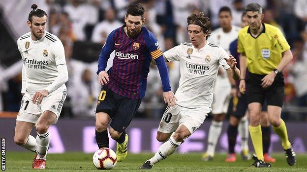 Real Madrid players Gareth Bale (left) and Luka Modric (right) try to get the ball off Barcelona's Lionel Messi (centre) during an El Clasico match