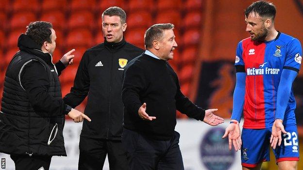 Inverness CT manager John Robertson (C) speaks Brad McKay regarding the penalty as assistant manager Scott Kellacher speaks to fourth official David Lowe.