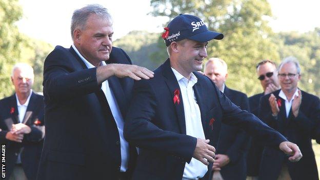 Russell Knox is presented with his winner's jacket after clinching the Travelers Championship in Connecticut