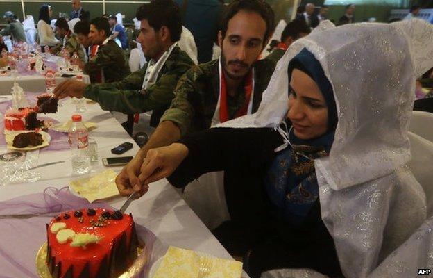 A couple cut their wedding cake at the mass wedding party