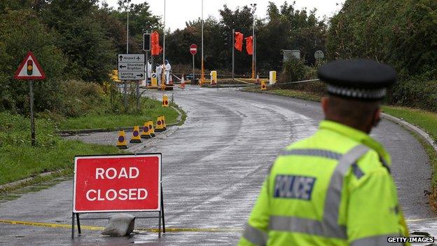 A policeman looks towards the scene of the crash