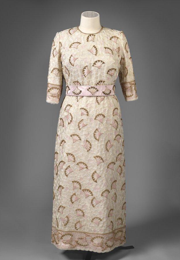 John Anderson designed this silk evening dress entirely embroidered with beads and sequins in white, pink, gold and cream with gold thread. It was worn by The Queen for the Commonwealth Heads of Government reception held at the Palace of Holyroodhouse in 1997