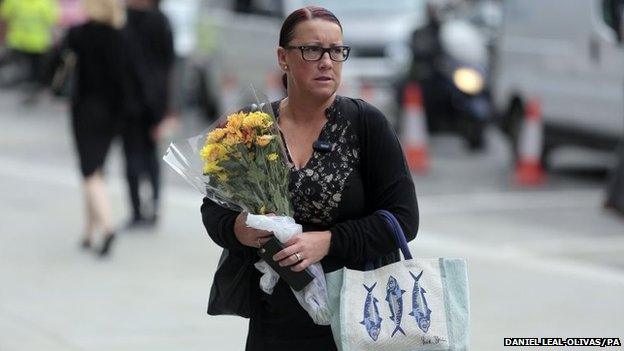 A lady arrives with flowers at Aldgate Station, London