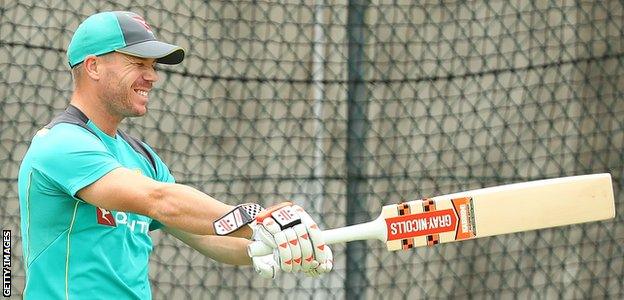 Australia's David Warner stretches in the nets