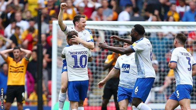 Connor Jennings is mobbed by his Tranmere team-mates after his winner against Newport