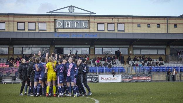 Dulwich Hamlet players celebrating in a team huddle