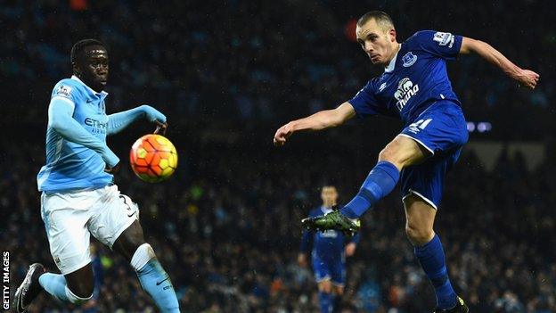 Leon Osman (right) hits a volley for Everton against Manchester City