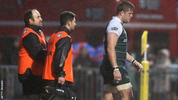 An injured Ed Slater (right) leaves the field