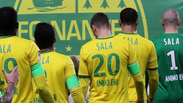 Nantes players line up wearing Sala shirts