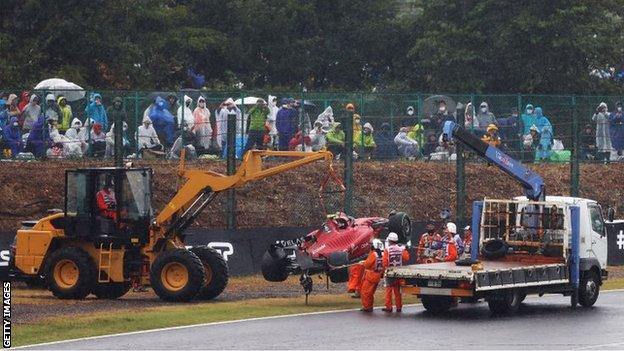 Recovery trucks remove Carlos Sainz's Ferrari