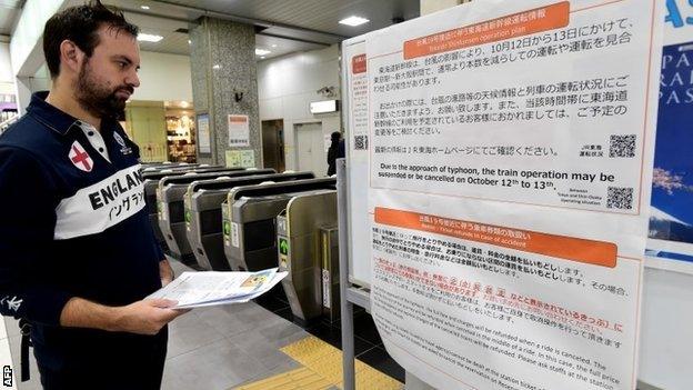 An England fans reads a travel warning in Japan