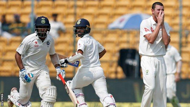 Cheteshwar Pujara (left) and Ajinkya Rahane run between the wickets as Australia's Josh Hazlewood looks on