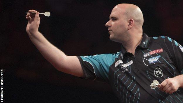 Rob Cross throws a dart