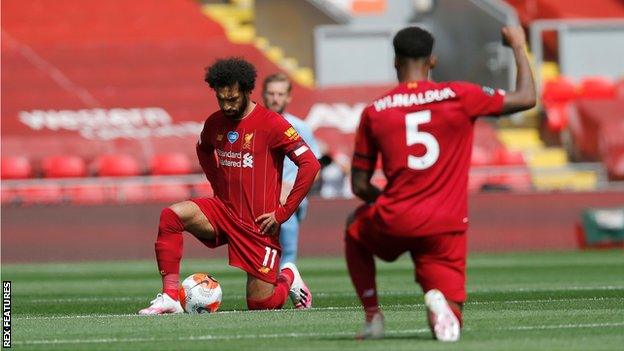 Mohamed Salah and Georginio Wijnaldum of Liverpool take a knee