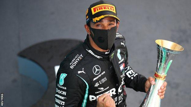 Lewis Hamilton celebrates with the winners trophy