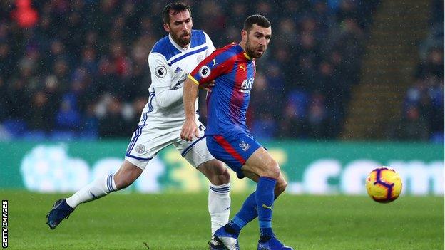 Crystal Palace midfielder James McArthur shields the ball from Leicester left-back Christian Fuchs