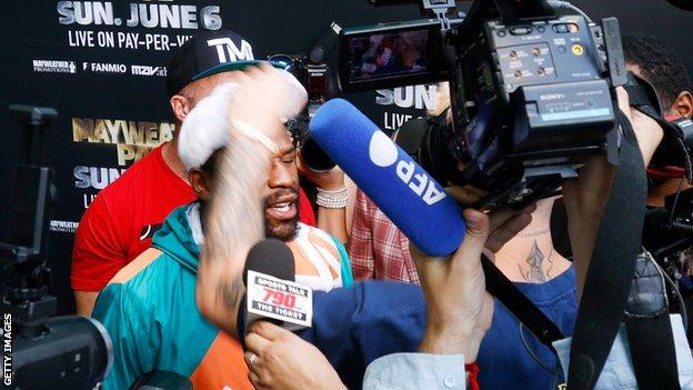 Floyd Mayweather (centre-left) and Jake Paul (behind camera)