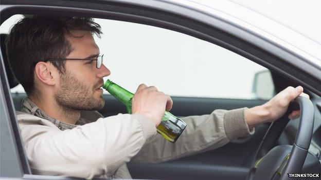 Man drinking beer while driving