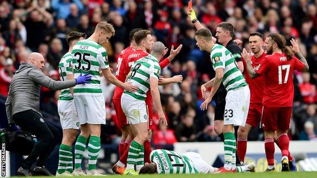 Dominic Ball is shown a second yellow card for a horrible aerial challenge on Celtic's Ryan Christie