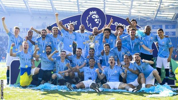 The Manchester City squad celebrate with the Premier League trophy