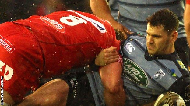 Scarlets back-rower Will Boyde tackles Blues scrum-half Tomos Williams