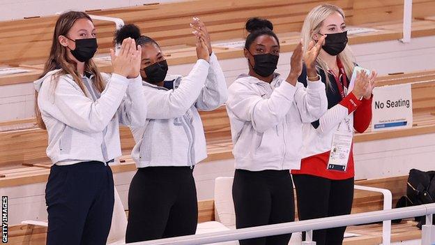 Simone Biles applauding with three team-mates