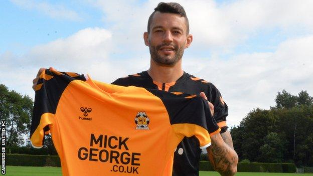 Marc Richards poses with a Cambridge United shirt