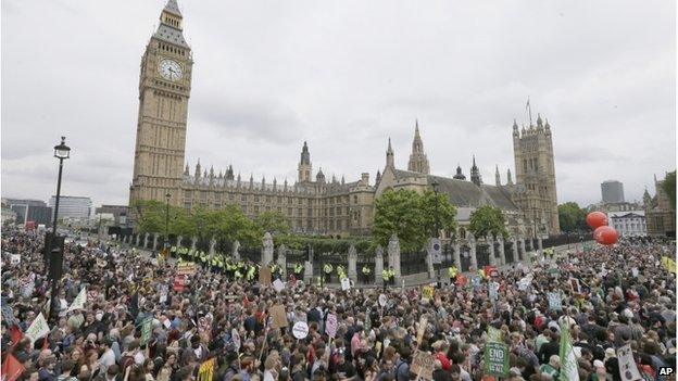 Anti-austerity protesters march past the Palace of Westminster