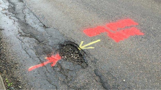 The council has now painted out the graffiti but not repaired the pothole