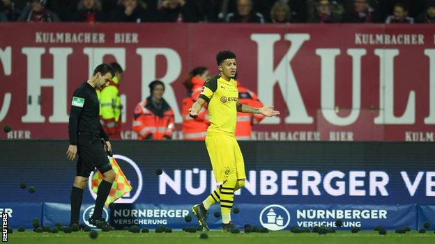 The match was halted twice as fans threw black tennis balls on the pitch