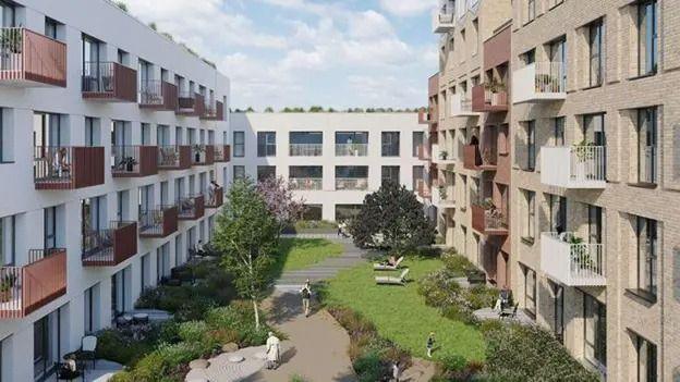 An artists's impression of four-storey blocks of flats around a central grass area. The flats have balconies overlooking the green