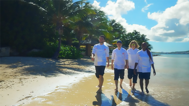 Four MasterChef finalists stroll on the beach in the Caribbean.