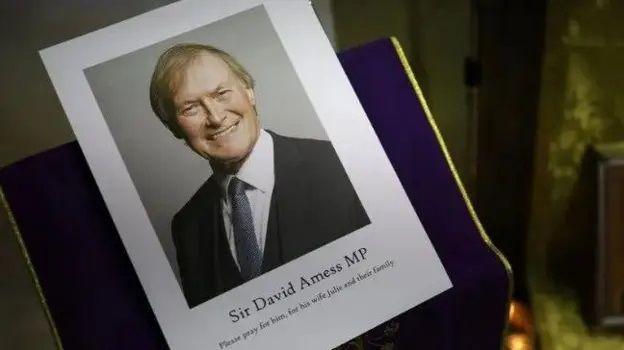 A photograph of a smiling Sir David Amess displayed at St Peter's Catholic Church as a Mass was said for him