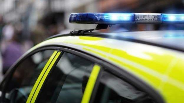 The top of a police car showing its lights flashing blue. 