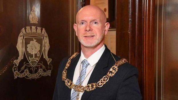 Philip Braat - a bald man wearing a suit and the Lord Provost's chain of office - looks into the office while in an office