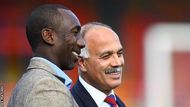 Shahid Azeem smiling in club tie alongside Jimmy Floyd Hasselbaink