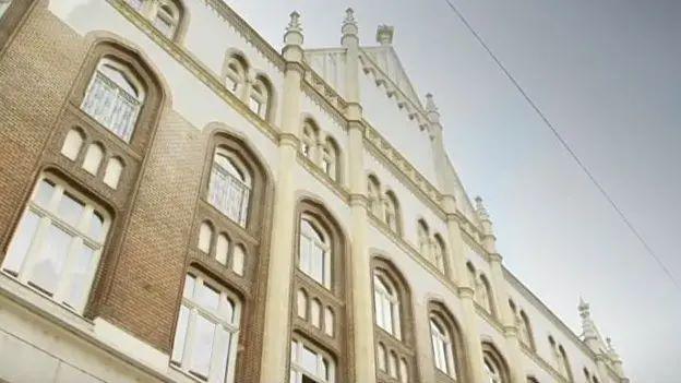 A brown and white building with lots of windows.
