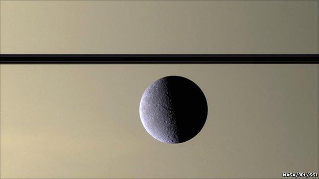 Rhea pictured in front of Saturn (Nasa/JPL/SSI)