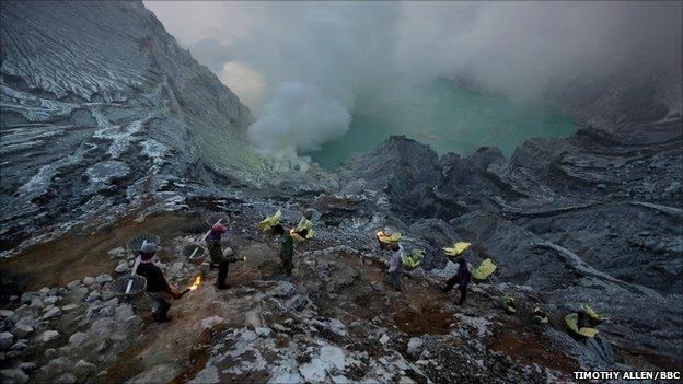 A procession of miners in the crater of Ijen volcano in East Java, Indonesia